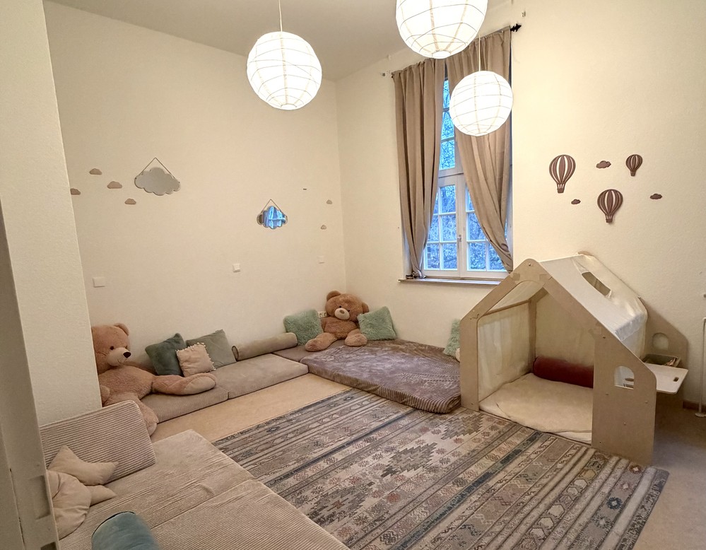 Gemütlicher Ruheraum mit Matten, Kissen und Spielhaus