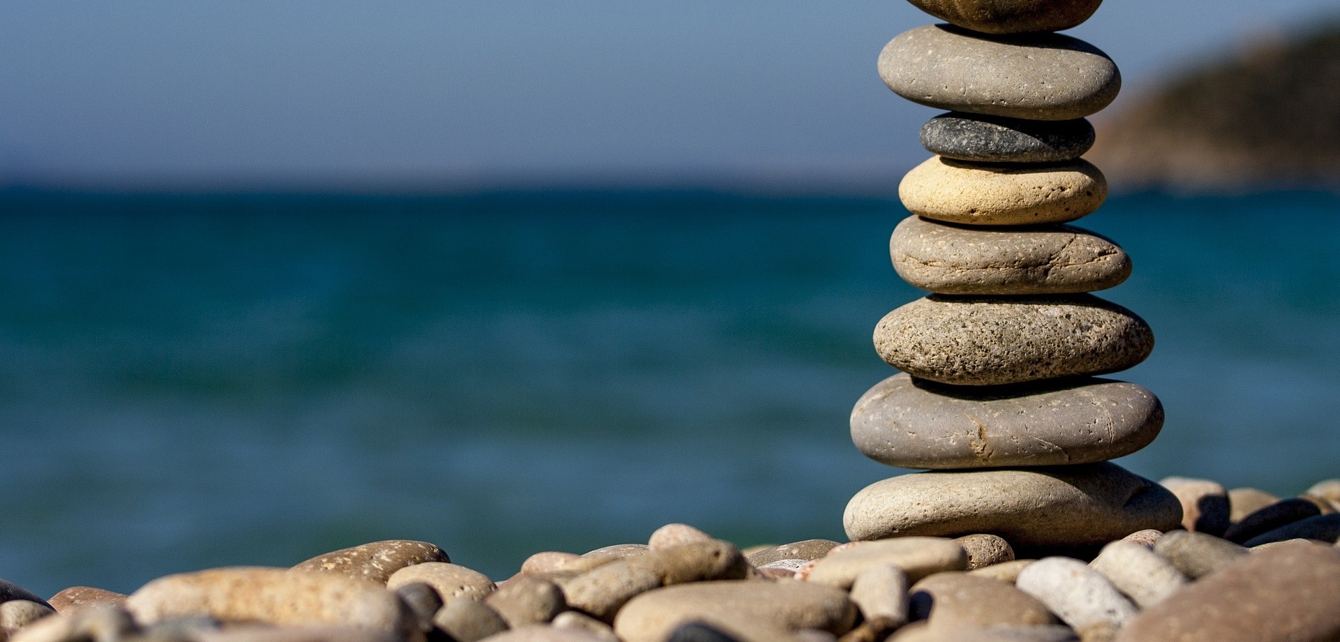 Aus vielen einzelnen flachen und runden Steinen am Strand ist ein kleiner Turm in die Höhe gebaut worden