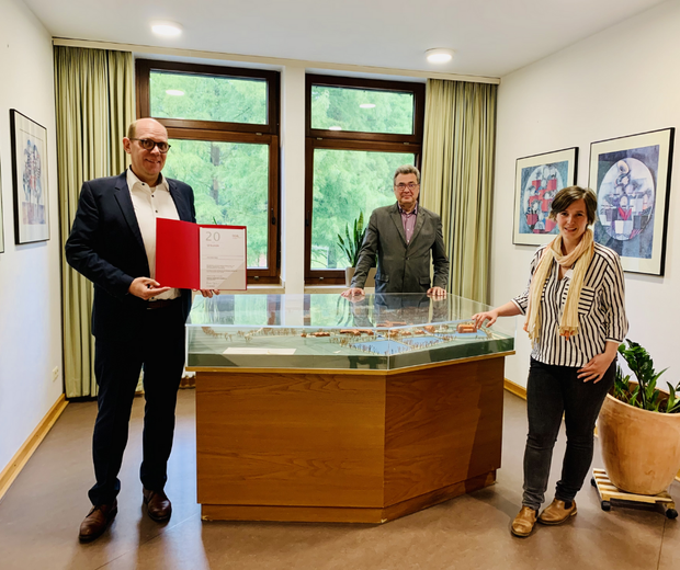 Stephan Köchling zeigt das DGQ-Zertifikat im Beisein von Heinz Augustin und Anne Sophie Scholz.
