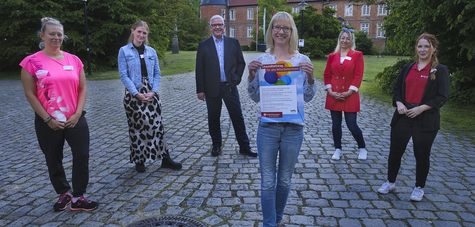 Das Organisationsteam des Gesundheitstages mit Vertretern und Vertreterinnen der Klinik und der Knappschaft steht vor dem Schloss.