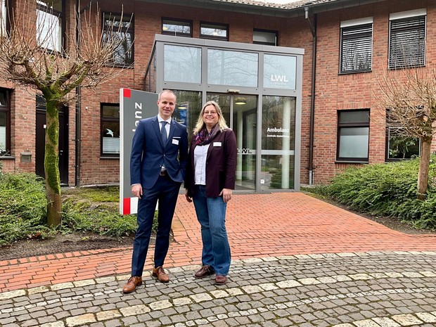 Ein Mann und eine Frau stehen vor der LWL-Klinik Herten