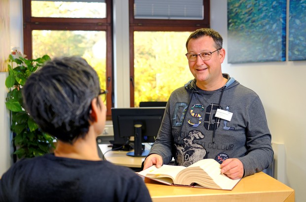 Mitarbeiter der Patientenverwaltung im Gespräch mit einer Frau