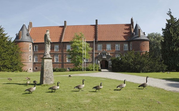 Das Schloss der LWL-Klinik Herten bei Sonnenschein und mit Kanadagänsen im Vordergrund auf der Wiese. Bildquelle: LWL/Ritzenhoff