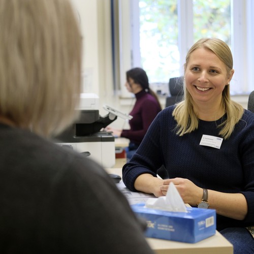 Eine Person im Gespräch mit einer Mitarbeiterin der Klinik.