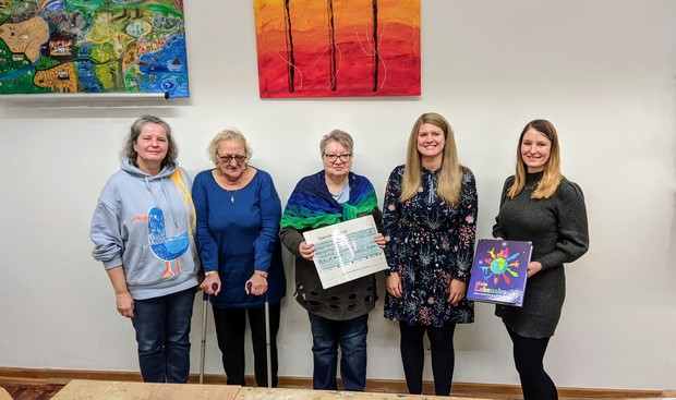 Fünf Frauen stehen nebeneinander und halten einen symbolischen Scheck in den Händen. Fünf Frauen stehen nebeneinander und halten einen symbolischen Scheck in den Händen.