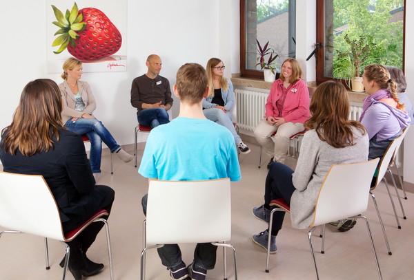 In einem Kreis sitzt eine Gruppe von Menschen auf Stühlen, die miteinander reden. Bildquelle: LWL/Dirk Kaltenhäuser