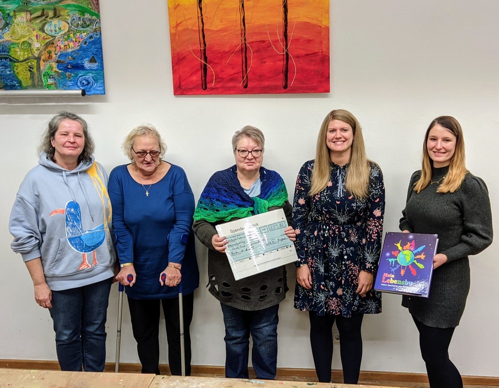 Fünf Frauen stehen nebeneinander und zeigen den symbolischen Scheck.