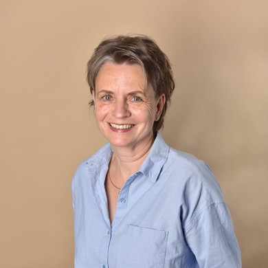 Eine Frau die in die Kamera lächelt.